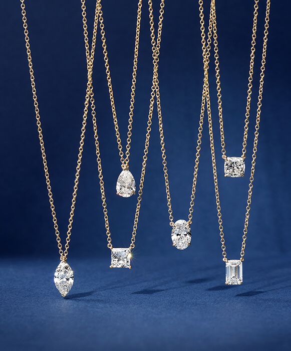 assorted diamond shape necklaces hanging on display